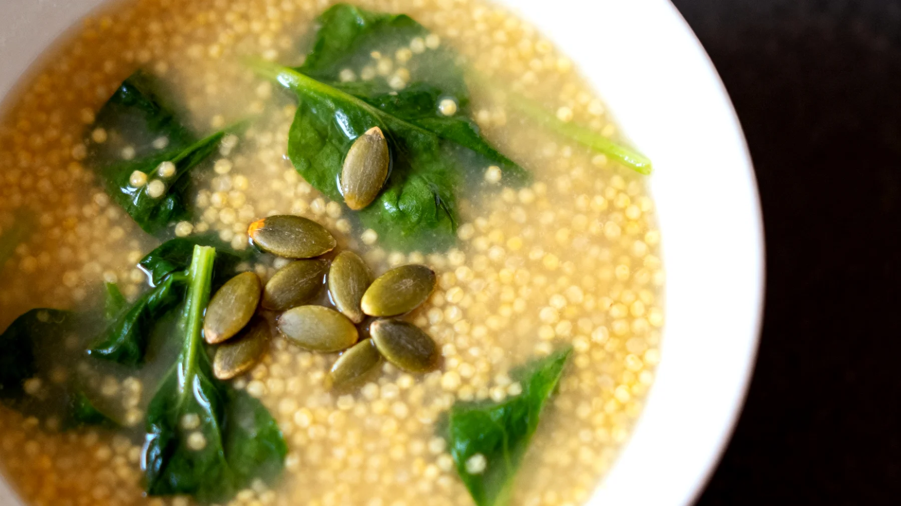 Zuppa di miglio con verdure a foglia verde e semi di zucca"
