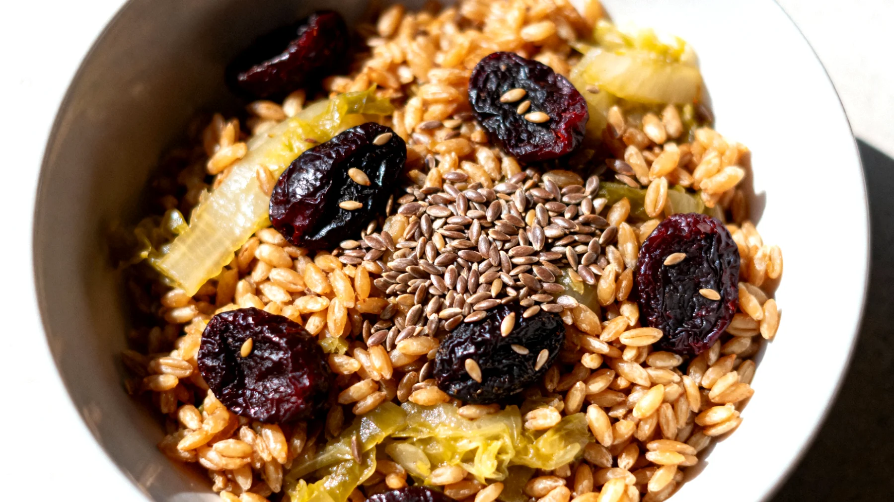 Insalata di farro con prugne secche, semi di lino e verdure fermentate"